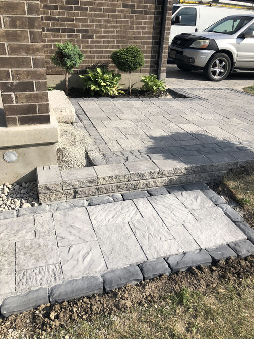 Front entry with step to side walkway. Stone steps or faux stone steps project by the London Ontario based O'Connor Stone & Landscape
