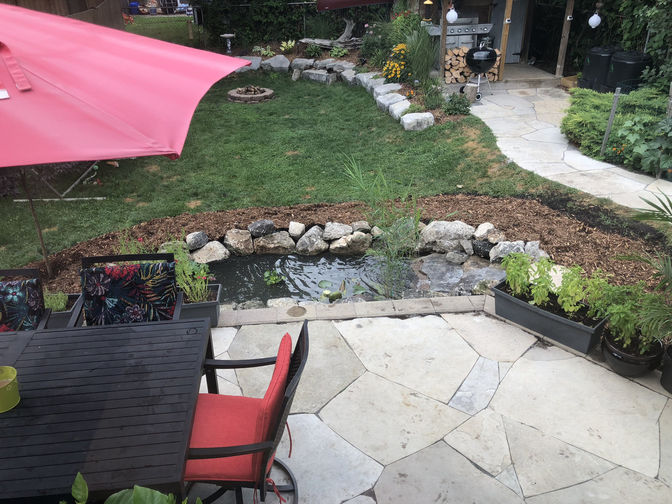 Random flagstone patio and a pond. A natural stone patio and water feature project in London Ontario region by O'Connor Stone & Landscape.