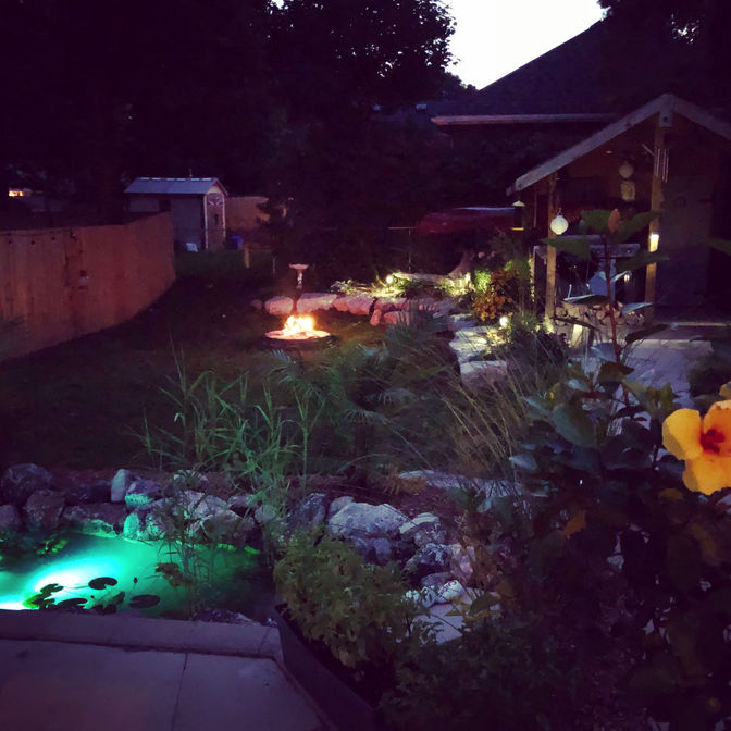 Night view of pond with landscape lighting. Water feature project in London Ontario region by O'Connor Stone & Landscape