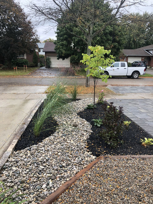 Driveway side landscape. A paver driveway and landscape project in London Ontario region by O'Connor Stone & Landscape, a contracor.