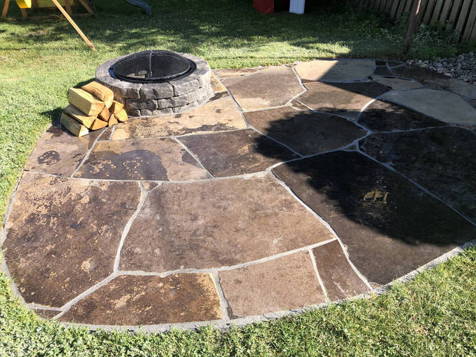 Random flagstone patio with fire pit. A random stone patio with fire pit project in London region by O'Connor Stone & Landscape.