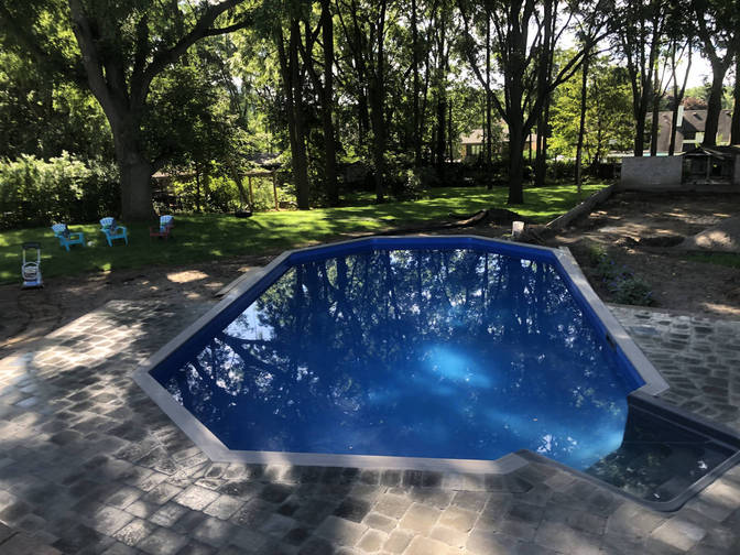 Stone paver pool deck, wall and steps. A retaining wall, paver deck and steps project by the London Ontario based O'Connor Stone & Landscape